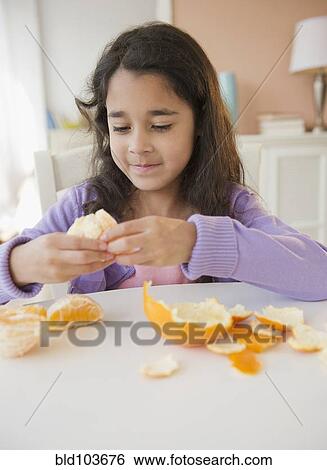 Mixed race girl peeling an orange View Large Photo Image Stock Photograph - Mixed race girl peeling an orange. Fotosearch