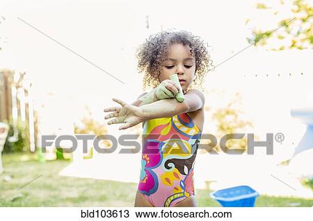 Mixed race girl putting chalk on her arm View Large Photo Image Stock Image - Mixed race girl putting chalk on her arm. Fotosearch