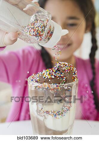 Mixed race girl putting sprinkles on ice cream View Large Photo Image Stock Photo - Mixed race girl putting sprinkles on ice cream. Fotosearch