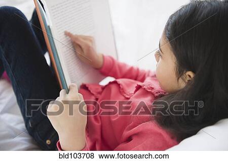 Stock Photo - Mixed race girl reading a book. Fotosearch