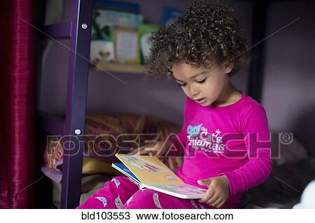 Stock Image - Mixed race girl reading book. Fotosearch