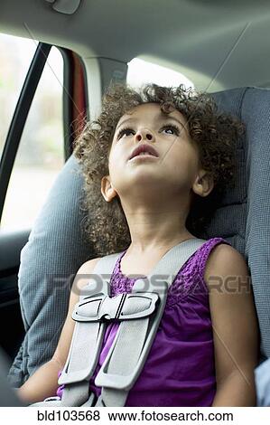 Stock Photo - Mixed race girl sitting in car seat. Fotosearch