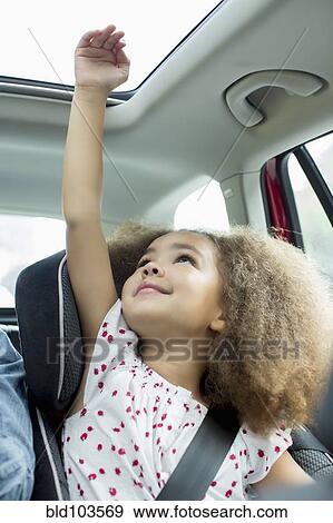 Mixed race girl sitting in car seat with arm out window View Large Photo Image Stock Photo - Mixed race girl sitting in car seat with arm out window. Fotosearch