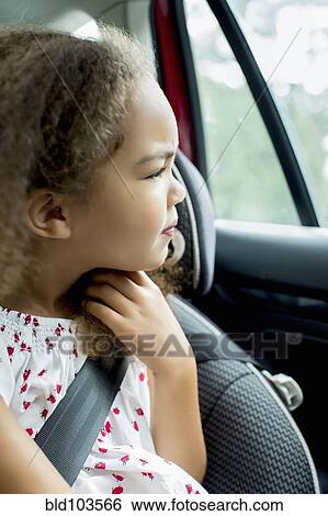 Stock Photograph - Mixed race girl sitting in car seat. Fotosearch