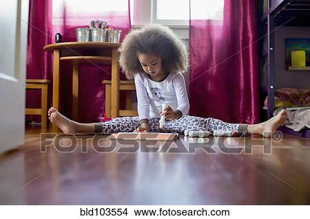 Picture - Mixed race girl sitting on floor drawing. Fotosearch