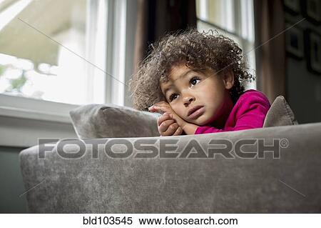 Mixed race girl sitting on sofa View Large Photo Image Stock Photography - Mixed race girl sitting on sofa. Fotosearch