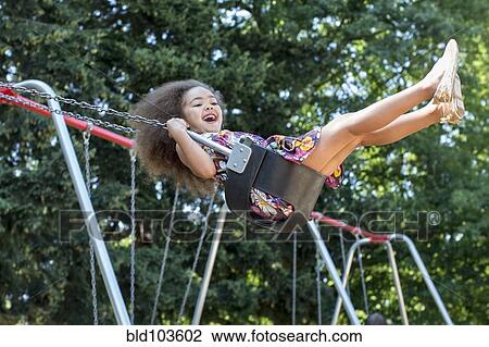 Mixed race girl swinging View Large Photo Image Stock Image - Mixed race girl swinging. Fotosearch