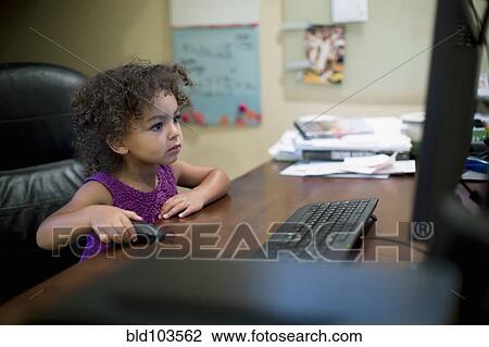 Stock Image - Mixed race girl using computer. Fotosearch