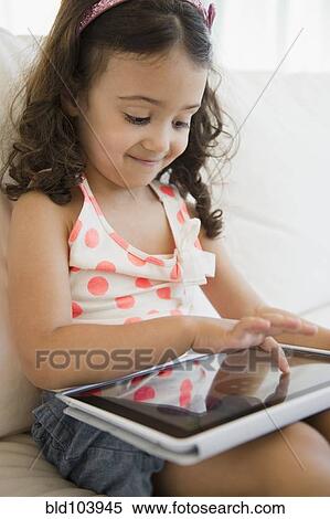 Stock Photography - Mixed race girl using digital tablet. Fotosearch