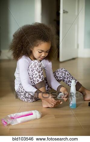 Stock Photograph - Mixed race girl using polish remover. Fotosearch