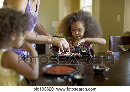 Mixed race girls eating dinner View Large Photo Image Stock Image - Mixed race girls eating dinner. Fotosearch