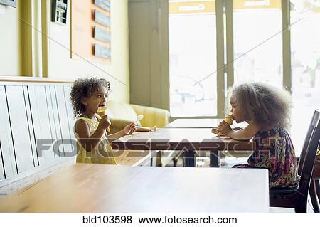 Stock Photo - Mixed race girls eating ice cream cones. Fotosearch
