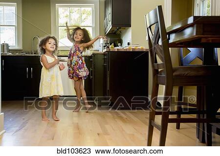 Mixed race girls playing in kitchen View Large Photo Image Stock Image - Mixed race girls playing in kitchen. Fotosearch