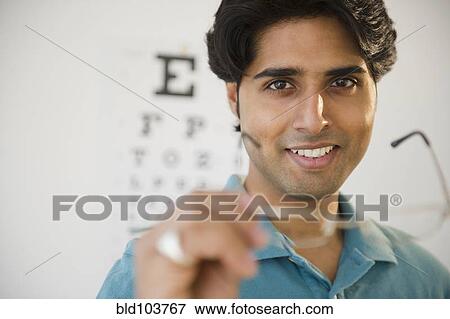 Mixed race man taking of eyeglasses View Large Photo Image Stock Photo - Mixed race man taking of eyeglasses. Fotosearch