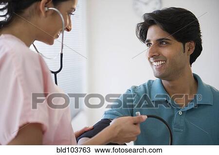 Mixed race nurse taking patient's blood pressure View Large Photo Image Stock Image - Mixed race nurse taking patient's blood pressure. Fotosearch