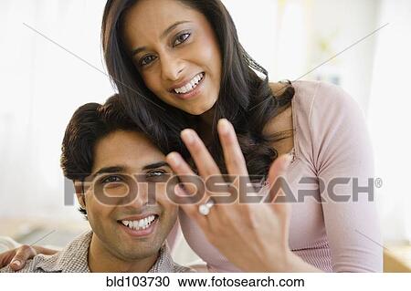 Stock Image - Mixed race woman showing off engagement ring. Fotosearch
