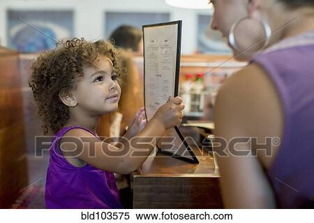 Stock Photography - Mother and daughter ordering in restaurant. Fotosearch