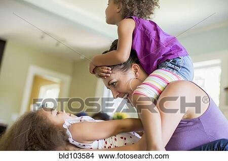 Picture - Mother and daughters playing. Fotosearch