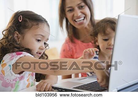 Stock Photograph - Mother watching children using laptop. Fotosearch