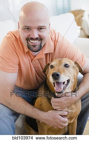 Smiling man hugging dog View Large Photo Image Picture - Smiling man hugging dog. Fotosearch