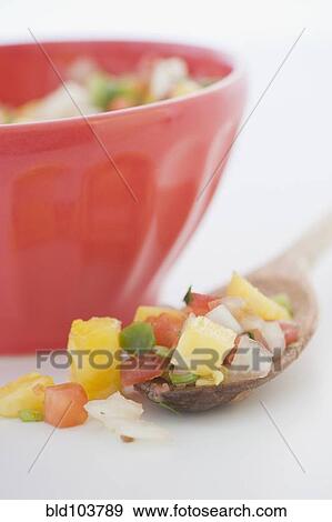 Stock Photo - Spoonful of salsa next to bowl. Fotosearch