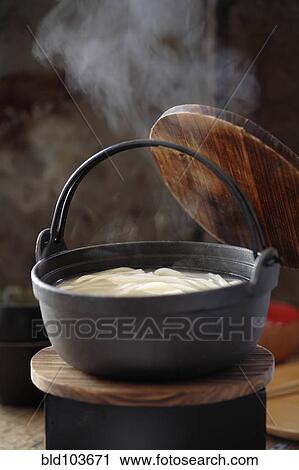 Stock Image - Steaming pot of soup with udon noodles. Fotosearch