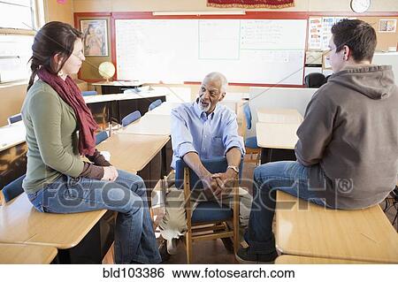 Stock Photograph - Teacher and students talking in classroom. Fotosearch