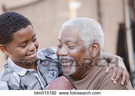 Stock Image - African American grandfather and grandson with football. Fotosearch