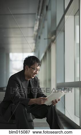 Asian businessman reviewing paperwork View Large Photo Image Stock Photo - Asian businessman reviewing paperwork. Fotosearch