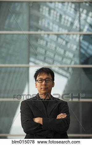 Stock Photo - Asian businessman with arms crossed. Fotosearch