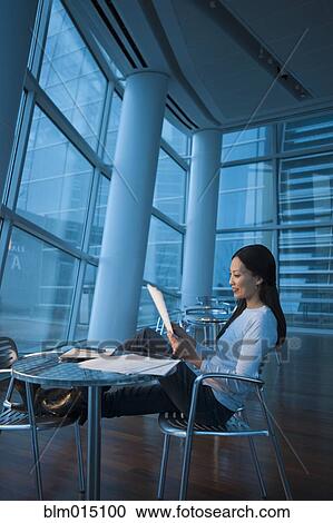 Stock Image - Asian businesswoman looking at paperwork. Fotosearch