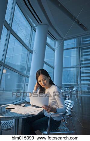 Asian businesswoman looking at paperwork View Large Photo Image Stock Photo - Asian businesswoman looking at paperwork. Fotosearch
