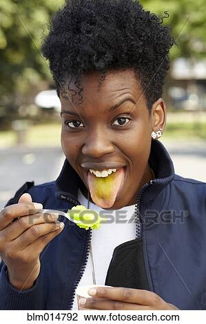 Stock Image - Black woman eating ice cream. Fotosearch