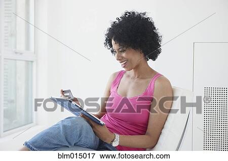 Stock Photo - Black woman using digital tablet. Fotosearch