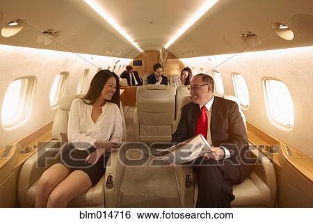 Stock Photograph - Business people flying on private jet. Fotosearch