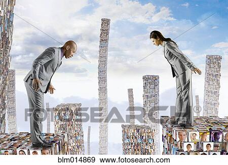 Stock Photo - Business people standing on buildings made of faces. Fotosearch