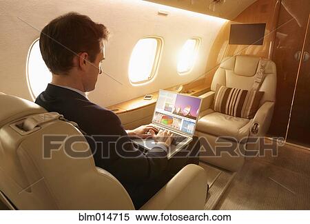 Businessman working on private jet View Large Photo Image Stock Photography - Businessman working on private jet. Fotosearch