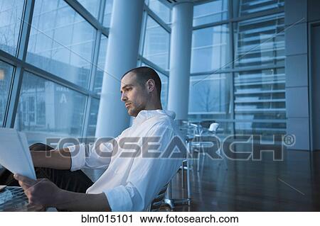 Stock Image - Caucasian businessman looking at paperwork. Fotosearch