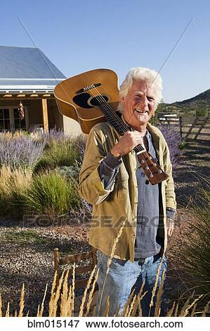 Stock Photo - Caucasian man holding guitar. Fotosearch