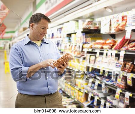 Caucasian man shopping in grocery store View Large Photo Image Stock Photo - Caucasian man shopping in grocery store. Fotosearch