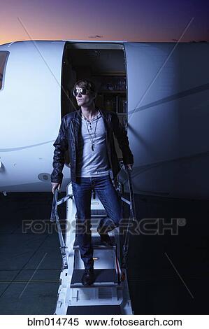 Stock Photography - Caucasian man walking down steps of private jet. Fotosearch