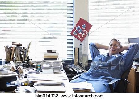 Stock Image - Caucasian man working at desk. Fotosearch