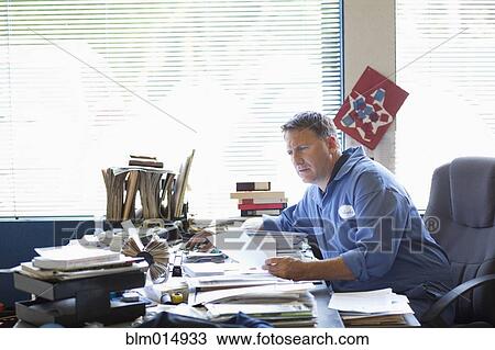 Caucasian man working at desk View Large Photo Image Stock Image - Caucasian man working at desk. Fotosearch