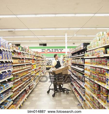 Stock Photo - Caucasian man working in grocery store. Fotosearch