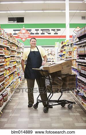 Stock Photo - Caucasian man working in grocery store. Fotosearch