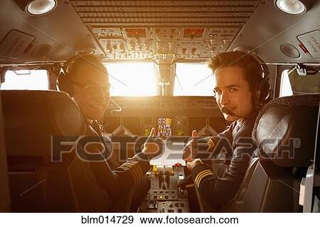 Stock Photo - Caucasian pilots flying jet at sunset. Fotosearch