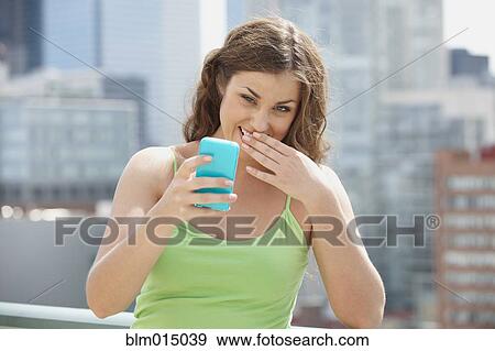 Stock Photo - Caucasian woman text messaging on cell phone. Fotosearch