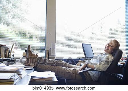 Caucasian woman with feet on desk View Large Photo Image Stock Photography - Caucasian woman with feet on desk. Fotosearch
