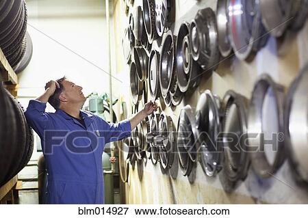 Stock Photo - Caucasian worker in tire store. Fotosearch