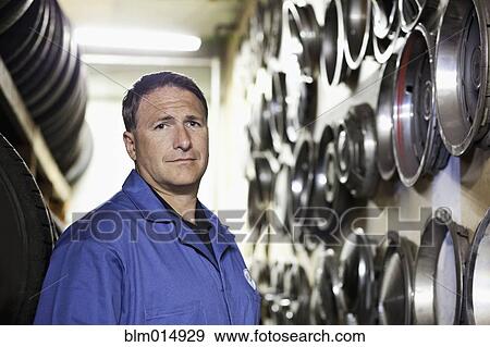 Stock Photo - Caucasian worker in tire store. Fotosearch